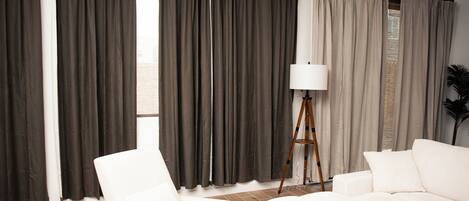 Un salon avec un canapé blanc, un fauteuil blanc et une lampe sur pied.