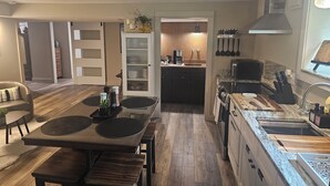 A modern kitchen with a dining area, wooden flooring, and built-in cabinets.