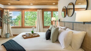 A hotel room with a bed, a tray with items, a potted plant, and large windows. - 🏔️ Four Sisters Mountain Haven: Luxury, Hot Tub, Near Ski Lift & Village, $0 Cleaning & Pet Fee (Keystone)
