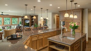 A spacious kitchen with granite countertops, wooden cabinets, and pendant lighting. - 🏔️ Four Sisters Mountain Haven: Luxury, Hot Tub, Near Ski Lift & Village, $0 Cleaning & Pet Fee (Keystone)