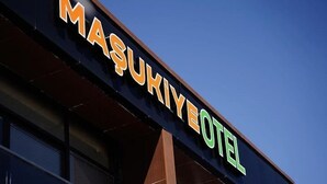 Das Außerein Gebäude mit der leuchtenden Schrifttafel 'MAŞUKIYE HOTEL'.