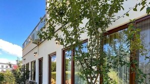 Ein modernes Haus mit Naturstein-Fassade, großen Fenstern und einem gepflegten Garten.