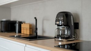 Una cocina con una cafetera negra sobre la encimera.