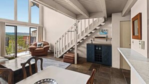 A modern interior with a dining area, a staircase, and a view of the outdoors. - Vista Viewhaus Lodge (Steamboat Springs)
