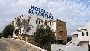 Ein Gebäude mit einem Schild, auf dem „HOTEL SPA EL CORTEJO“ steht.