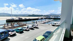 Un port de plaisance avec des bateaux amarrés, une plage de sable et un ciel dégagé.