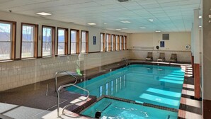 An indoor swimming pool with clear glass walls, a tiled floor, and a ceiling with fluorescent lights. - Kitchen, AC, deck, mountain view, pool, ski shuttle. LB307 by LRS (Lincoln)
