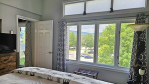 A bedroom with a large window, a bed, a dresser, and a lamp. - Kitchen, AC, deck, mountain view, pool, ski shuttle. LB307 by LRS (Lincoln)