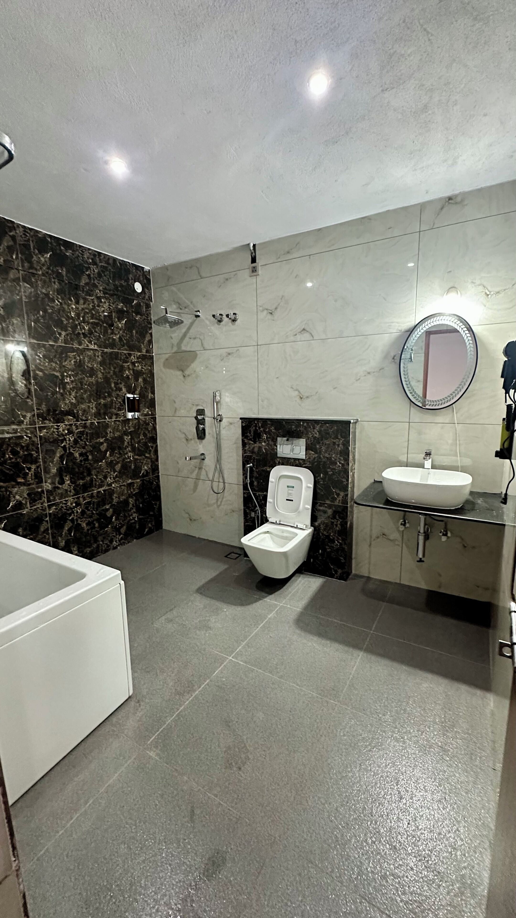A modern bathroom with a bathtub, toilet, and vanity.