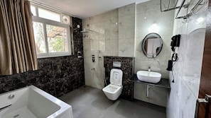 Une salle de bain avec une baignoire, des toilettes et un lavabo.