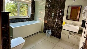 Un baño moderno con bañera, lavamanos y zona de ducha.