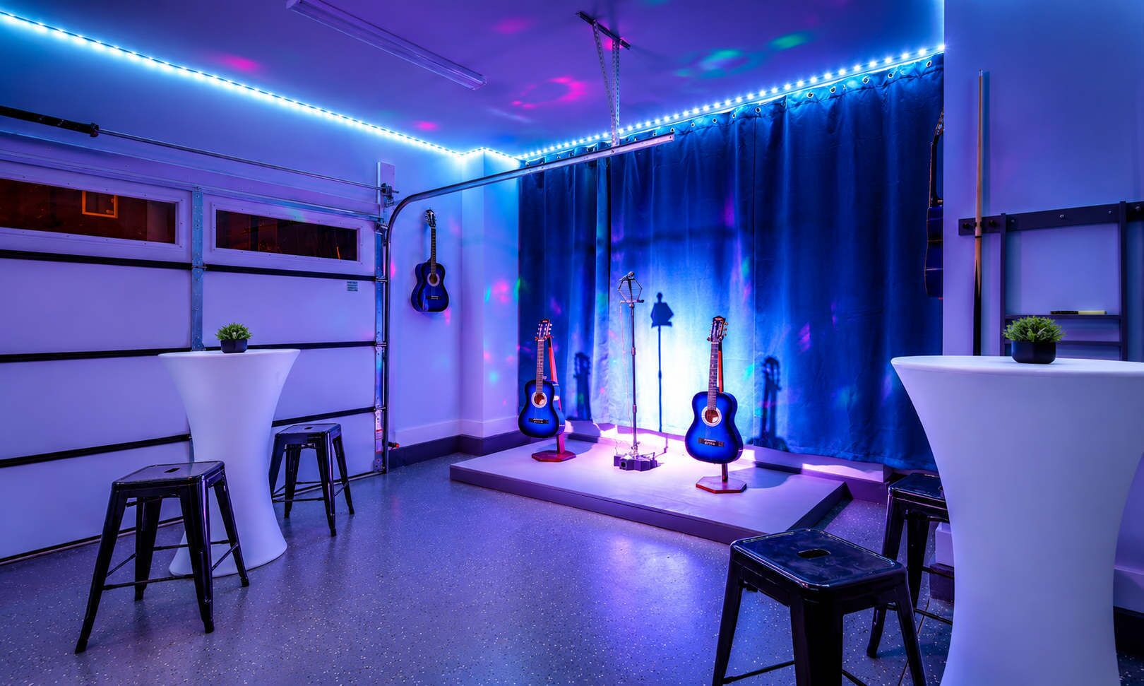 Una habitación con un escenario, taburetes y guitarras.