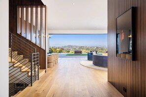 Un intérieur moderne avec un escalier, un téléviseur à écran plat et une vue sur l’extérieur.