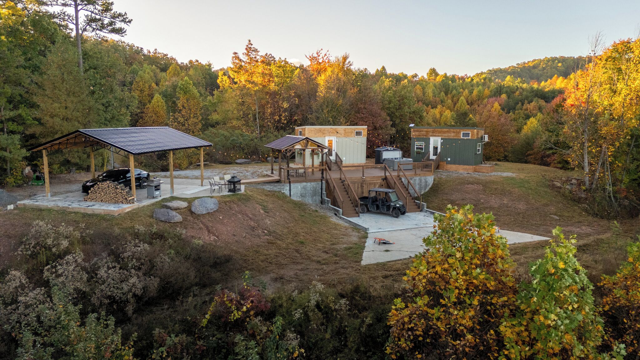 A cabin with a covered patio, outdoor seating, and a deck.