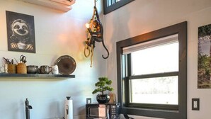 A modern kitchen with a built-in microwave, a sink, and two bar stools. - Tarzan And Jane Treehouse. Hot tub. Riverfront (Sevierville)