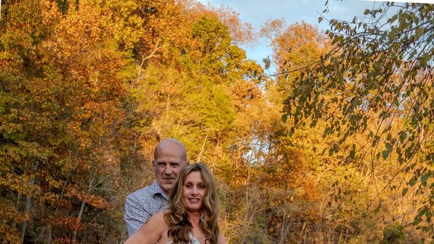 A couple standing in a river with autumn foliage in the background. - Tarzan And Jane Treehouse. Hot tub. Riverfront (Sevierville)