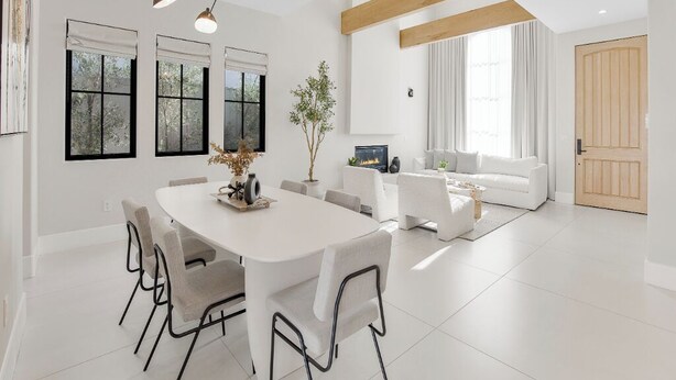 A modern living room with a white sofa, a dining table with chairs, and a fireplace. - Villa Camellia - Charming 5 BR Home in the heart of Studio City (Studio City)