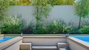 A poolside area with built-in seating and a wooden fence. - Villa Camellia - Charming 5 BR Home in the heart of Studio City (Studio City)