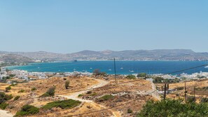 A coastal town with a view of the sea, a bridge, and hills in the background. - Cyclades Whisper (Milos)