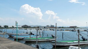 A marina with several boats docked, a concrete dock, and a clear sky with clouds. - Destiny Seaside Village (Sakaiminato)