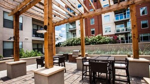 An outdoor patio area with wooden pergolas, tables, and chairs. - Stylish 2-bedroom in the Gulch - Walk to Nashville's hot spots! (Nashville)