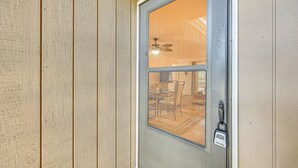A door with a frosted glass window, a ceiling fan, and a lock. - Fernandina Beach Condo w/ Pool + Path to Beach! (Fernandina Beach)