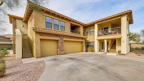 A two-story house with a stone facade, a covered front porch, and a balcony with outdoor furniture. - Phoenix Condo ~ 1 Mi to Desert Ridge Marketplace! (Phoenix)