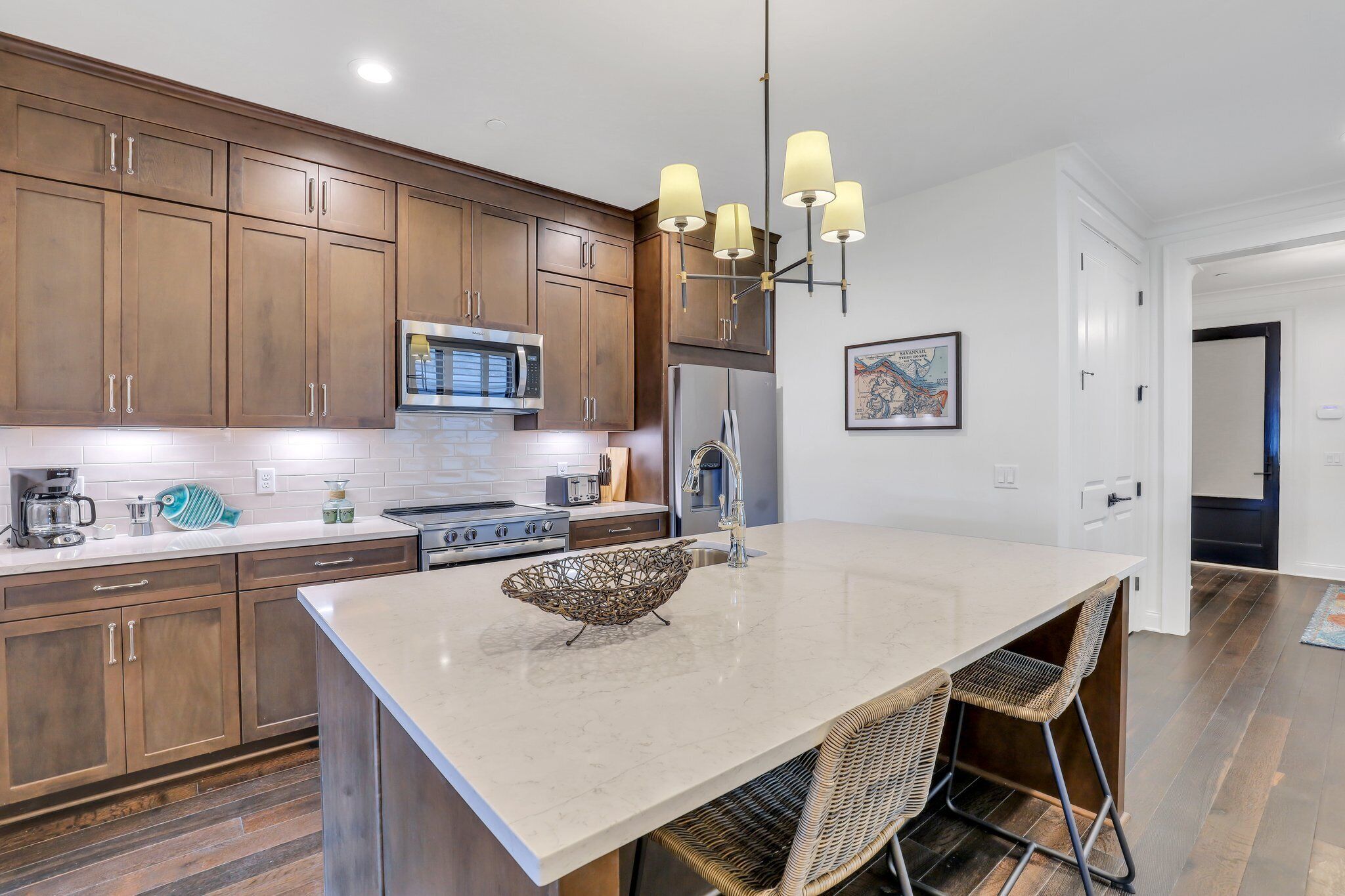 Una cocina moderna con armarios de madera, una isla central e iluminación colgante.