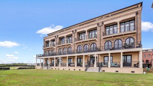 Een meerlaags gebouw met een centrale binnenplaats, met een reeks balkons en grote ramen.