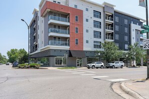 A multi-story building with a modern architectural design, featuring balconies and large windows.
