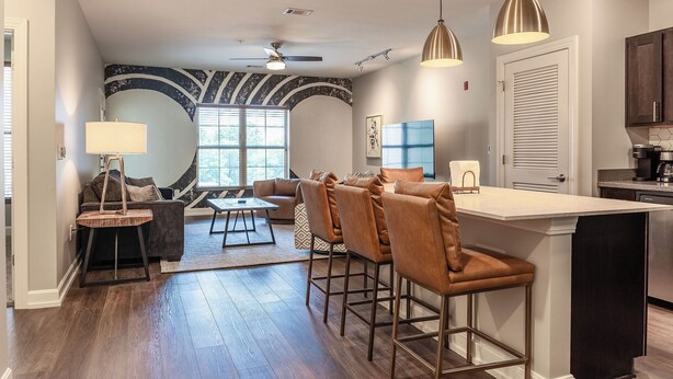 Una cocina moderna con barra, una mesa de comedor y un sofá en la sala de estar.