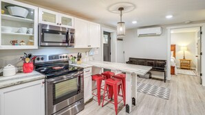 A modern kitchen with stainless steel appliances, red bar stools, and a marble countertop. - Walk to Downtown Weaverville: Quiet Apartment (Weaverville)