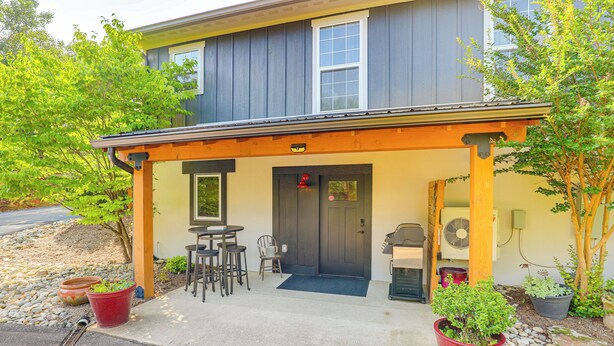 A building with a covered porch, outdoor seating, and potted plants. - Walk to Downtown Weaverville: Quiet Apartment (Weaverville)