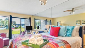 A hotel room with a large bed, a TV, a desk, and a view of the parking lot. - Waterfront Condo 5-Minute Walk to DT Bigfork (Bigfork)
