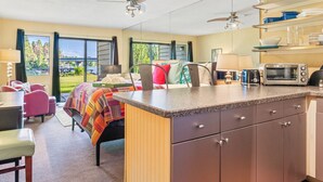 A modern kitchen with a central island, built-in appliances, and a view of the outdoors. - Waterfront Condo 5-Minute Walk to DT Bigfork (Bigfork)