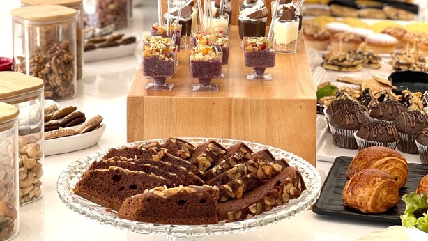 Une table de buffet proposant divers plats, notamment des desserts et des en-cas.