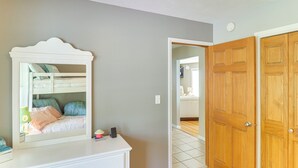 A bedroom with a bunk bed, a dresser, and a mirror. There is a wooden door and a tiled floor. - Lakeside Alexandria Retreat w/ Deck + Boat Dock! (Alexandria)
