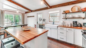 A modern kitchen with wooden beams, white cabinets, a wooden countertop, and a built-in oven. - Private Hot Tub: Tree-lined Poconos Home! (Pocono Summit)