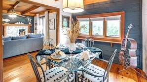 A dining area with a glass table, metal chairs, and a violin.