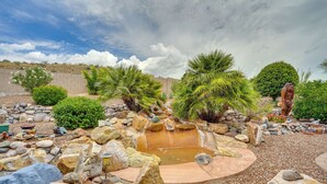 A landscaped garden with a small pond, rocks, and palm trees. - Spacious Home in Saddlebrooke 55-plus Community! (Saddlebrooke)