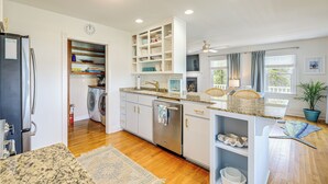 A modern kitchen with white cabinets, stainless steel appliances, and a granite countertop.