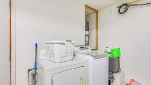 Un espace buanderie comprenant un lave-linge, un sèche-linge et un miroir.