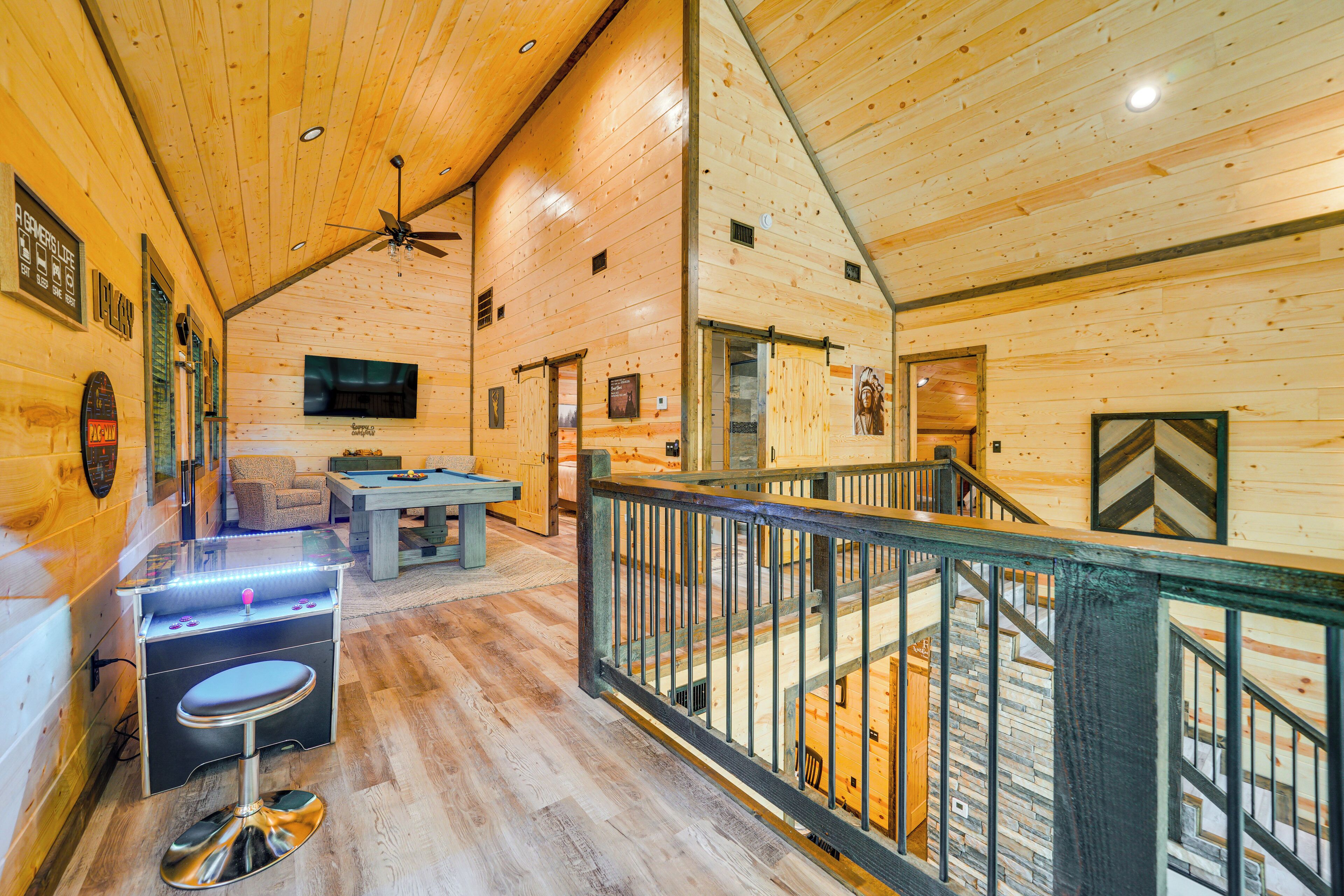 A wooden cabin interior with a bar area, a sofa, and a staircase.