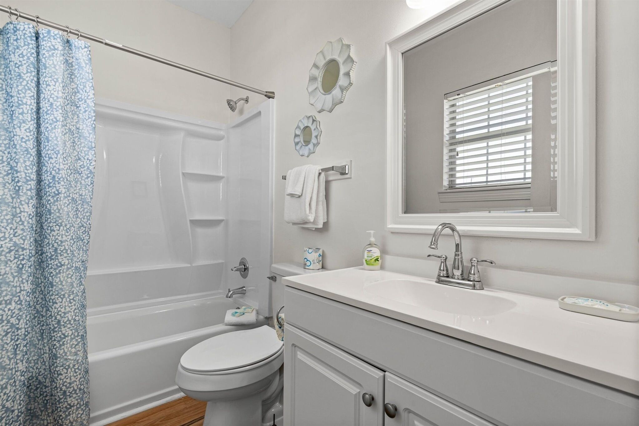 A bathroom with a bathtub, toilet, sink, and a shower curtain.