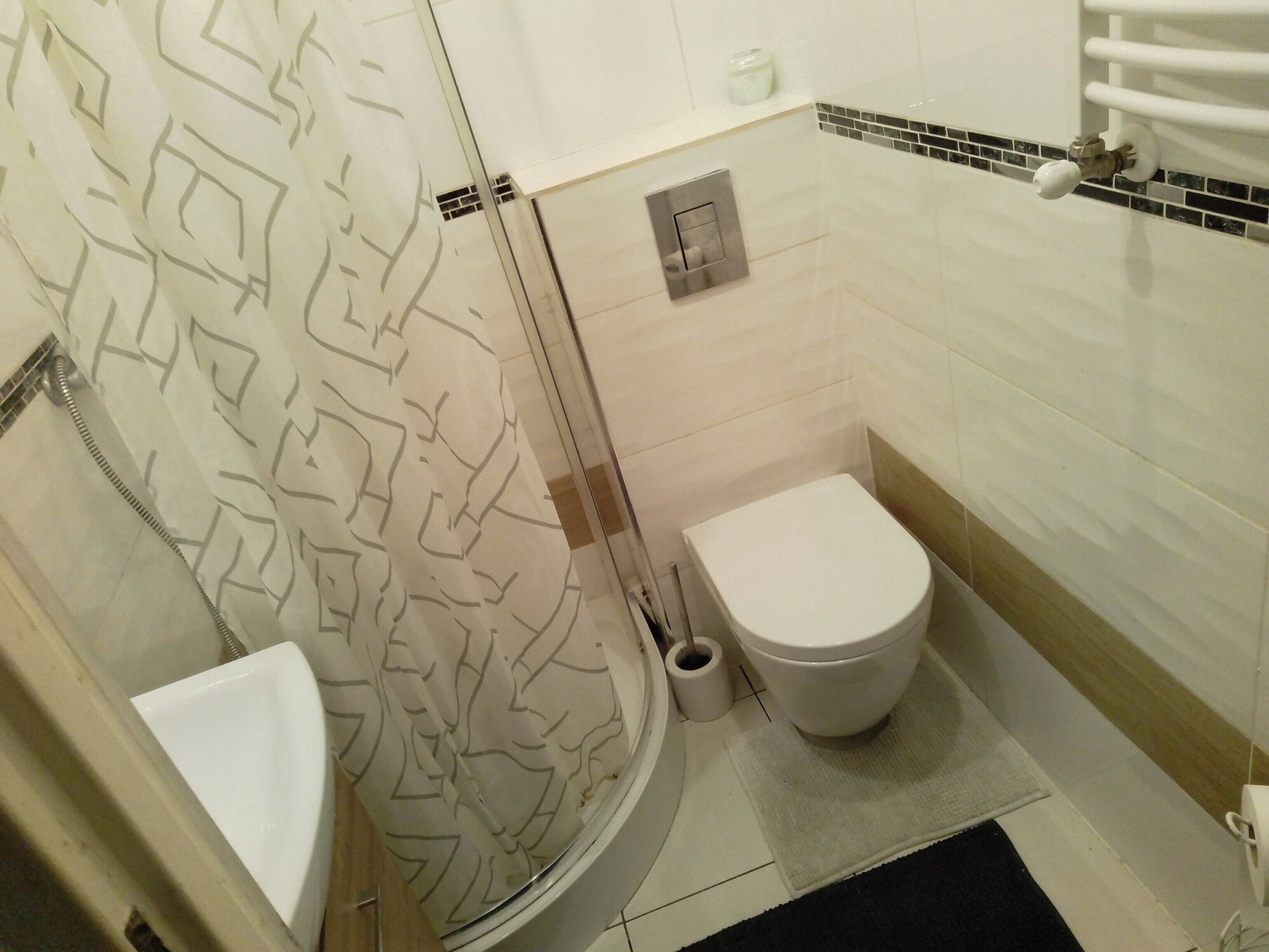 A bathroom with a toilet, a shower, and a sink.