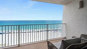 Un balcon avec vue sur une plage et l’océan.
