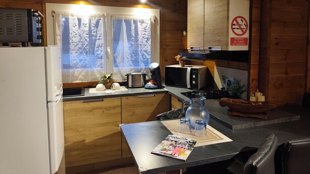 Una cocina compacta con gabinetes de madera, microondas, tostadora y cafetera.