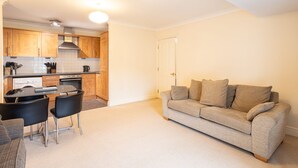 A compact living space with a kitchenette, a dining area, and a sofa.