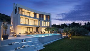 A modern two-story house with a swimming pool, outdoor seating, and a well-maintained lawn. - Lavish Villa O with Panoramic Elefiti Islands View, Six Bedrooms with a Pool (Dubrovnik)