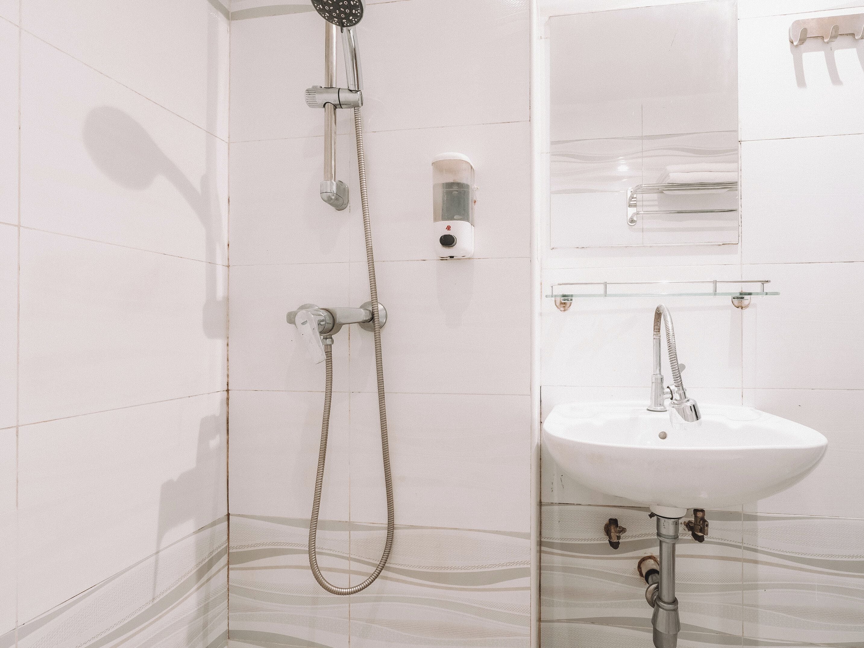 Une salle de bain moderne avec une douche, un lavabo et un miroir.
